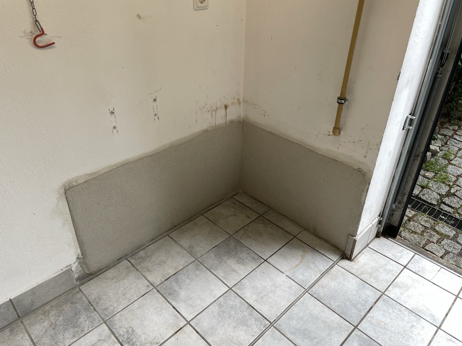 Nachher: derselbe Sockelbereich mit neu aufgetragenem Putz